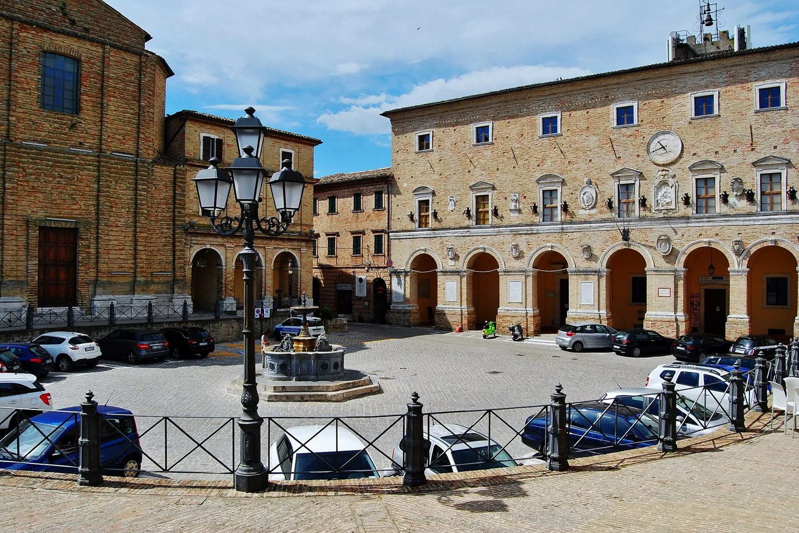 Piazza della Repubblica a Treia con la fontana, il palazzo comunale porticato e gli edifici in mattoni